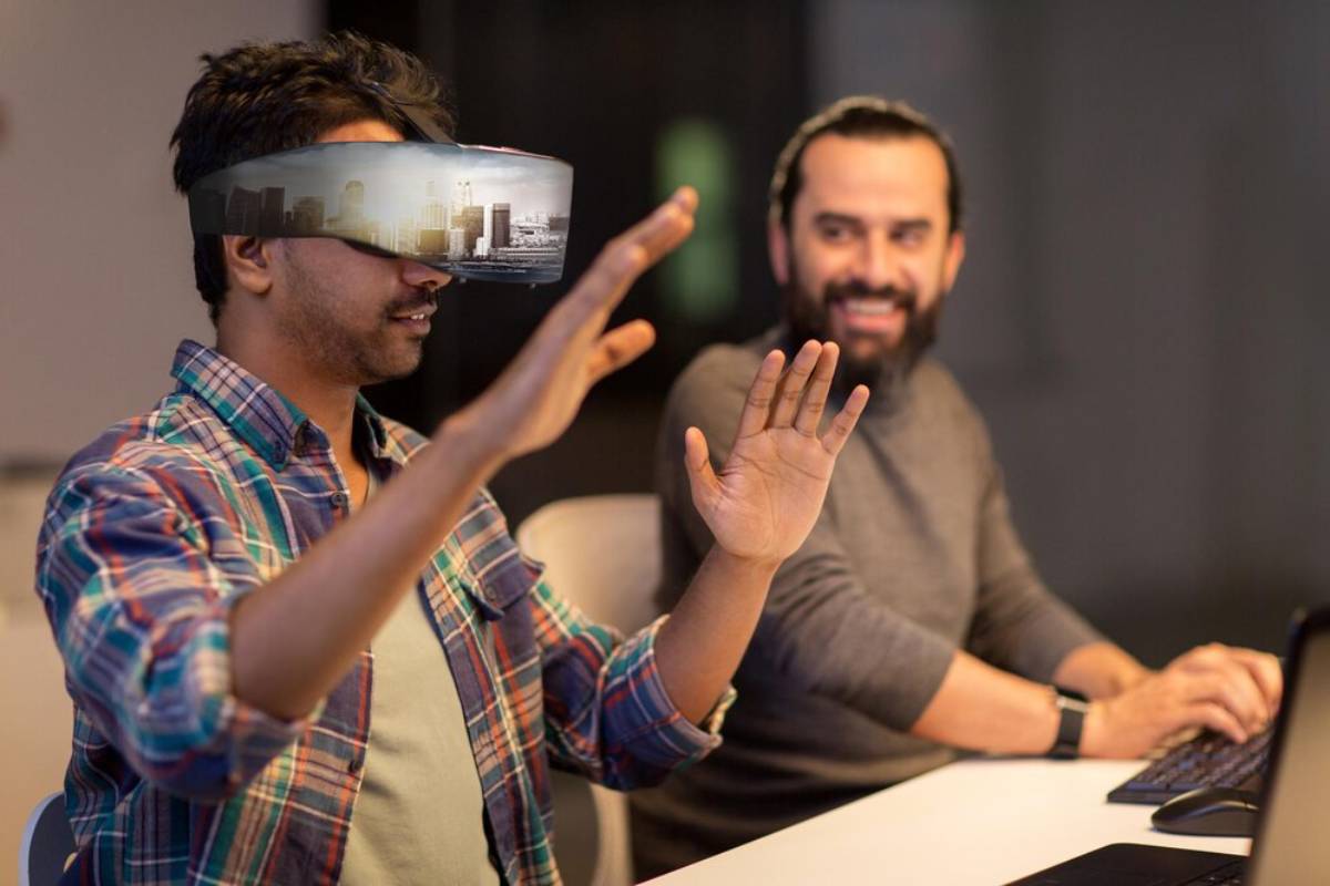 Two men using augmented reality headsets in an office; one is interacting with a virtual display.